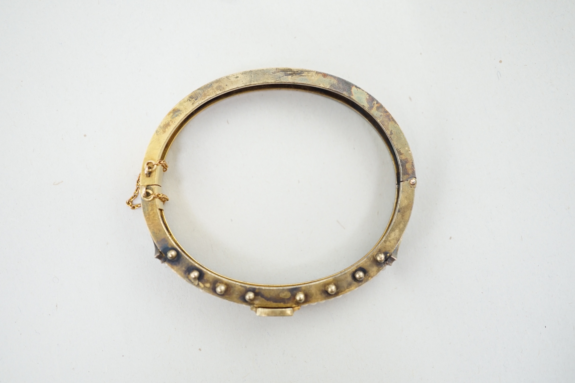 A Victorian, gold, single stone diamond and seed pearl and coral bead cluster set hinged bangle